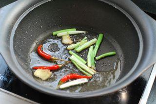 Lotus Root and Pork Stir-Fry step 5: Heat a little oil in a wok. Add ginger, scallions, and pickled chili peppers and